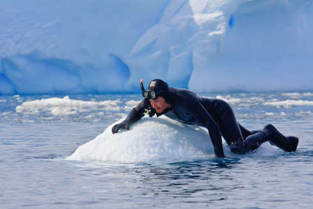 Diver on the ice against the blue iceberg. Antarcticaの写真素材