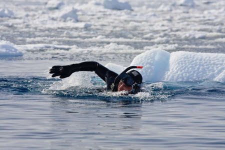 Diver among the ice against the blue iceberg. Antarcticaの写真素材