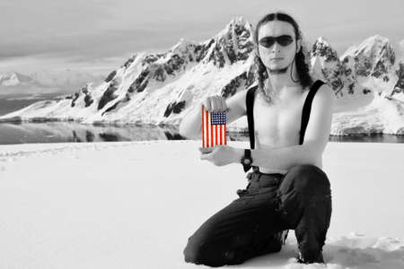 Man on top of the mountain holding a USA Flag. Antarctica.の写真素材