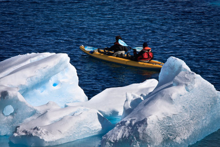 Two men in a canoe among icebergs in Antarcticaの写真素材