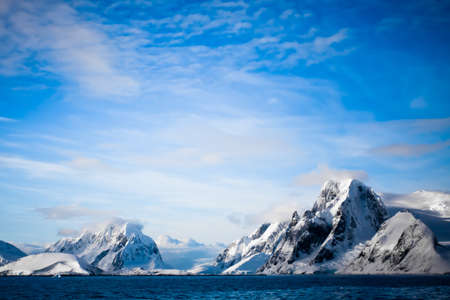 Beautiful snow-capped mountains against the blue sky in Antarcticaの写真素材