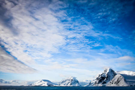 Beautiful snow-capped mountains against the blue sky in Antarcticaの写真素材