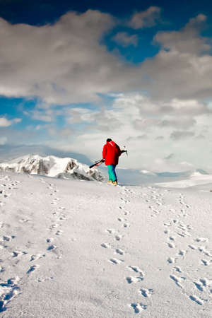 Man climbs on a snow slope with skis in hand. Antarctica.の写真素材