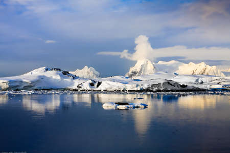 The mountains and their reflection in the water with ice. The clouds in the sky.の写真素材
