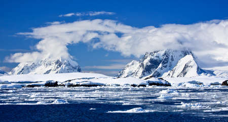 Beautiful snow-capped mountains against the blue sky in Antarcticaの写真素材