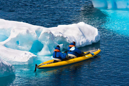 Two men in a canoe among icebergs in Antarcticaの写真素材