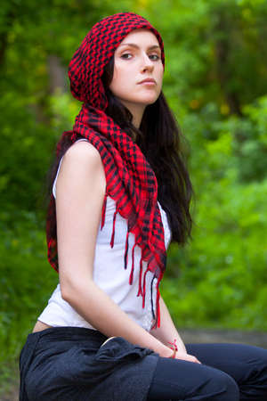 Girl sitting in the forest, on his head wearing a red kerchiefの写真素材