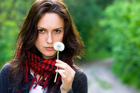 Girl holding in her hand a white dandelionの写真素材