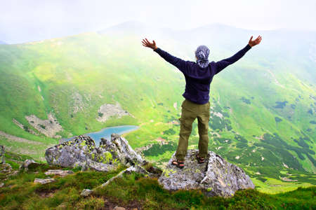 Beautiful mountains landscape with lake  in Carpathian mountains and man on the topの写真素材