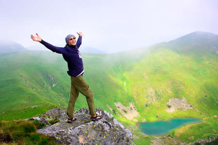 Beautiful mountains landscape with lake  in Carpathian mountains and man on the topの写真素材