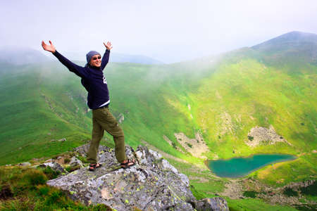Beautiful mountains landscape with lake  in Carpathian mountains and man on the topの写真素材