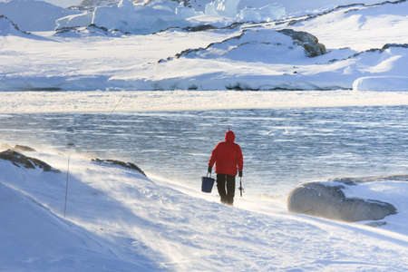 Man goes fishing in a snowstorm. Antarcticaの写真素材