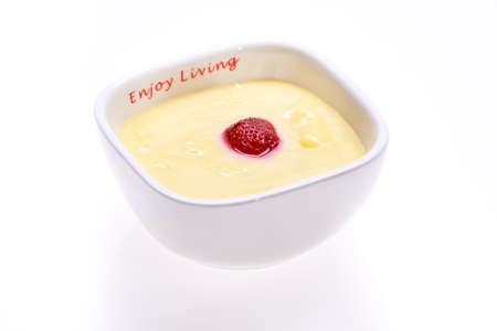 Custard with strawberries in a saucer isolated on whiteの写真素材