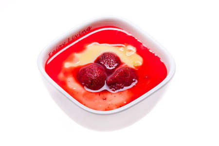 Custard with strawberries in a saucer isolated on whiteの写真素材