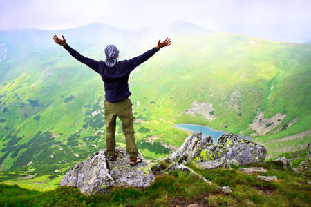 Beautiful mountains landscape with lake  in Carpathian mountains and man on the topの写真素材