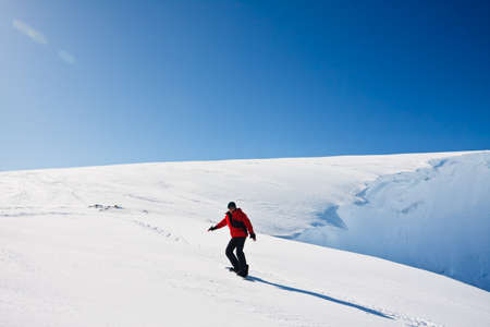Man moves on snowboard. Glacier in background. Antarcticaの写真素材