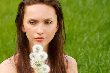 Girl with dandelion on green fieldの写真素材