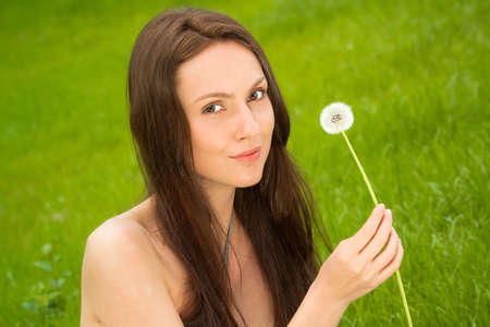 Girl with dandelion on green fieldの写真素材