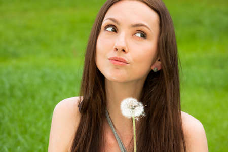 Girl with dandelion on the green fieldの写真素材