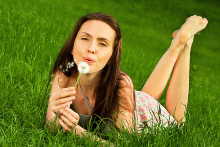 Girl with dandelion on green fieldの写真素材