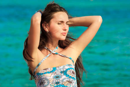 Beautiful young brunette resting at beach in summerの写真素材