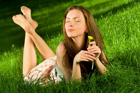 Girl with dandelion on the green fieldの写真素材