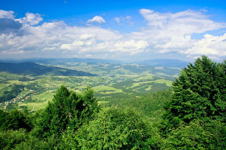 Blue cloudy sky and beautiful mountain landscape with treesの写真素材
