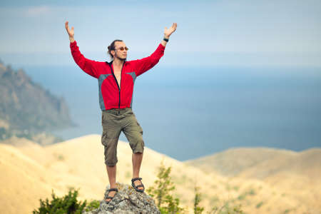 Man on top of mountain holding arms upの写真素材