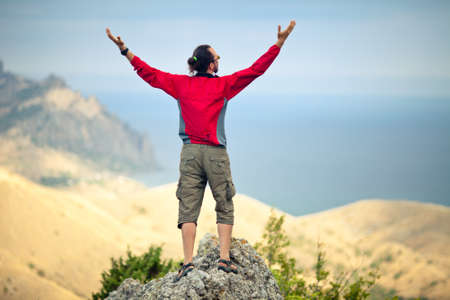 Man on top of mountain holding arms upの写真素材