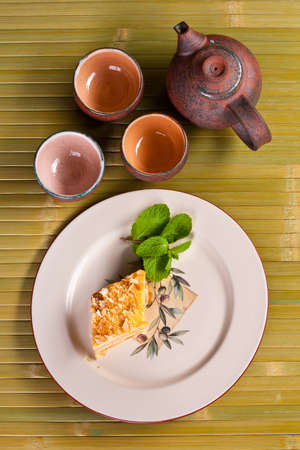 napoleon cake on white plate with cups for teaの写真素材
