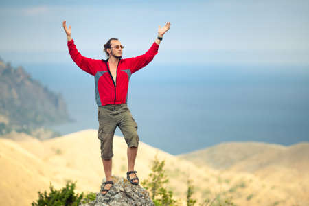 Man on top of mountain holding arms upの写真素材