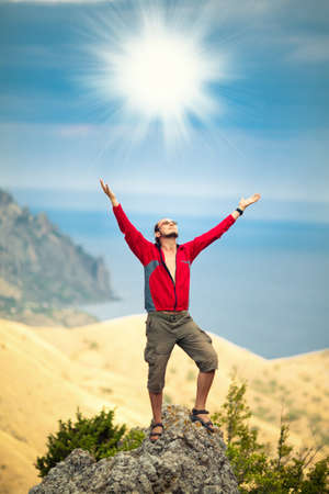 Man on top of mountain holding arms upの写真素材