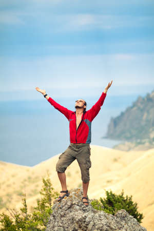 Man on top of mountain holding arms upの写真素材