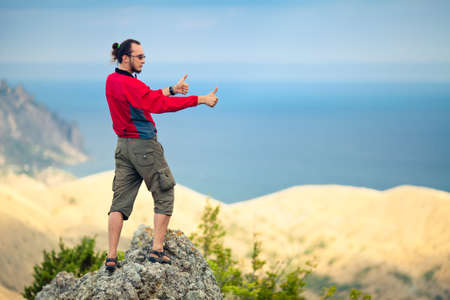 Man on top of mountain holding arms upの写真素材