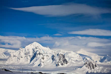 Beautiful snow-capped mountains against the blue sky in Antarcticaの写真素材