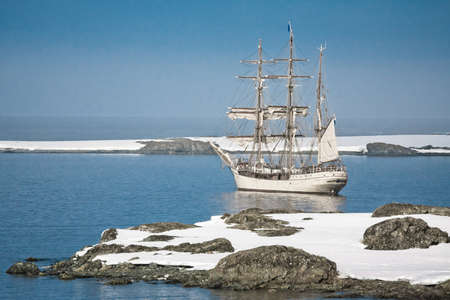 Sailing ship among the icebergs in Antarcticaの写真素材