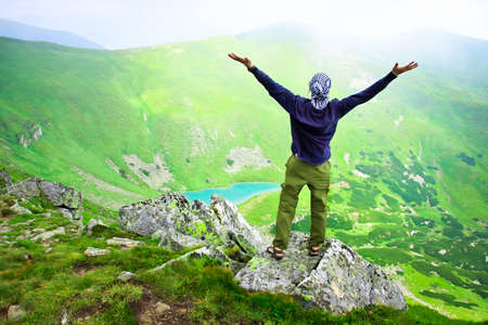 Beautiful mountains landscape with lake  in Carpathian mountains and man on the topの写真素材