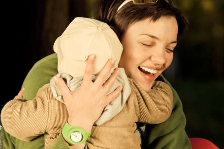 A mother and child playing in autumn parkの写真素材