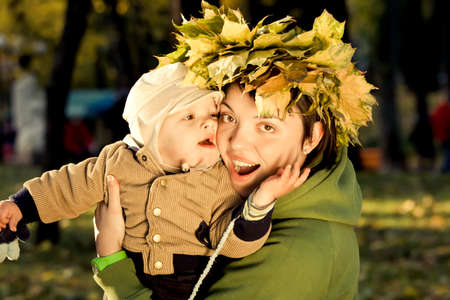 A mother and child playing in autumn parkの写真素材