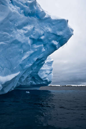 blue ice cave covered with snow and flooded with lightの写真素材