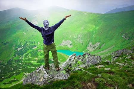 Beautiful mountains landscape with lake  in Carpathian mountains and man on the topの写真素材