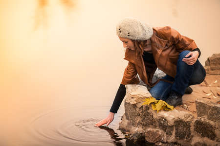 portrait of a beautiful girl sitting near lakeの写真素材