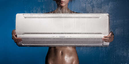 girl holds conditioner standing behind the glassの写真素材