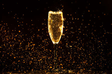 Champagne pouring in glass on a black backgroundの写真素材