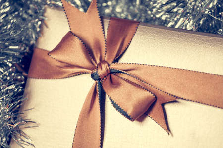 gift box with golden ribbon, glittery backgroundの写真素材