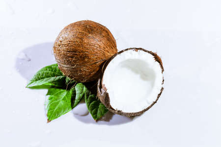 cracked coconut with big splash, isolated on whiteの写真素材