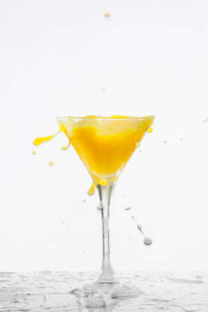 Orange cocktail with splashes on a white backgroundの写真素材