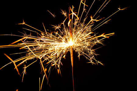 burning christmas sparkler isolated on blue backgroundの写真素材