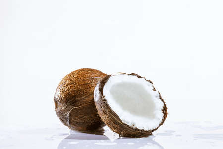 cracked coconut with big splash, isolated on whiteの写真素材