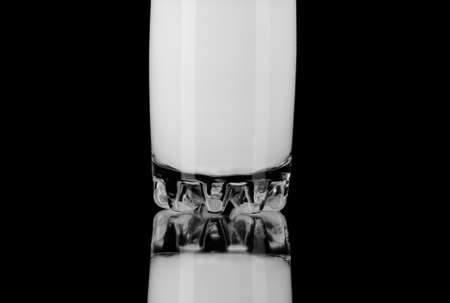 Milk in the glass isolated on black backgroundの写真素材